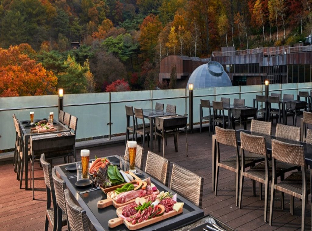 Outdoor BBQ dining table set on the terrace with mountain autumn foliage and observatory dome at Forest Resom