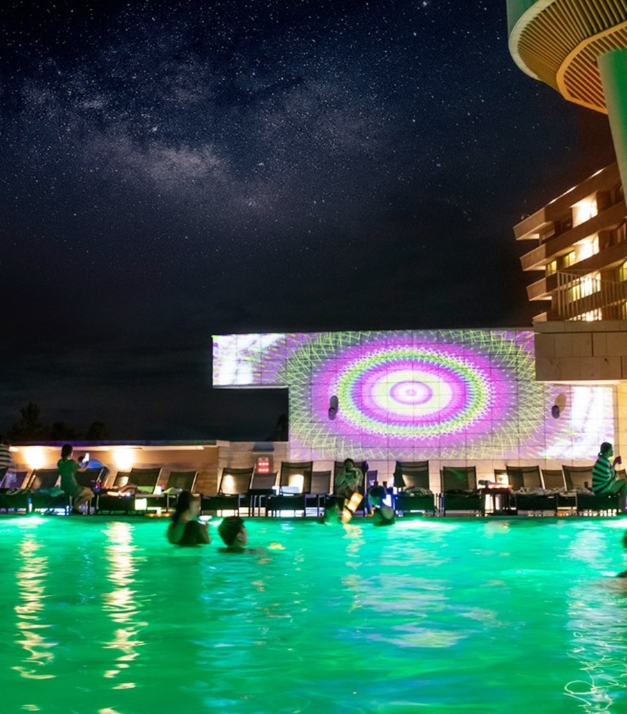 Night view of the heated infinity pool party at Hidden Cliff Hotel Jeju under a starry sky